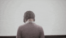 the back of a woman 's head with a bun on her hair