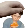 a person is eating a slice of pizza and a hand is reaching out to touch their head .