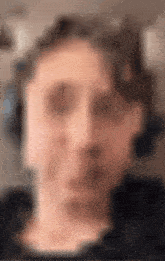 a blurry picture of a person 's face with headphones on .