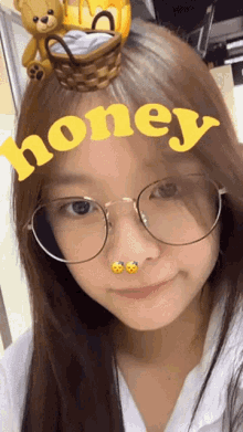a girl wearing glasses has a yellow honey sticker on her head