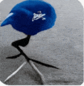 a blue bird wearing a dodgers hat is walking on the ground