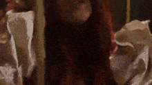 a woman with red hair is wearing a white ruffled shirt