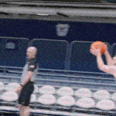 a man holding a basketball in front of a referee