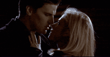 a man and woman are kissing in the dark