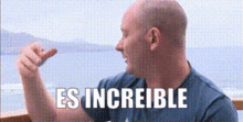 a bald man is giving a thumbs up and the words es increible are above him