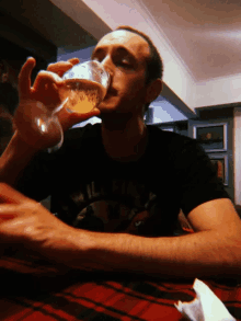a man drinking a glass of beer with a t-shirt that says ' california ' on it