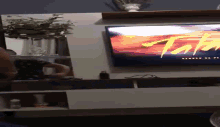 a person is sitting in front of a tv that says ' tnt ' on the screen