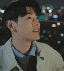 a close up of a man 's face with a blurry background of lights