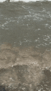 a close up of waves crashing on a rocky beach