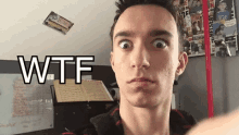 a young man is making a funny face with the words wtf written above him