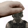 a hand is putting a gas mask on a man .
