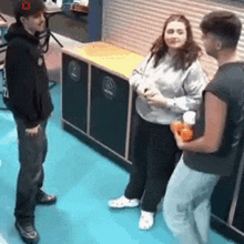 a group of people are standing around talking to each other in a room .