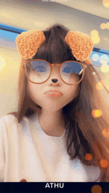 a girl wearing glasses and bear ears has the name athu on the bottom