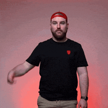 a man wearing a red hat and a black shirt with a shield on it