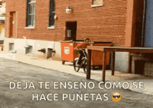 a man is riding a bike down a street next to a brick building .