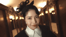 a woman wearing a black hat with a bow on it