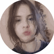 a girl with a choker around her neck is blowing a kiss in a circle