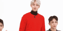 a man in a red sweater is holding a pink toy in his hand .