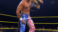 a man in a wrestling ring wearing a pair of blue and white striped pants