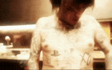 a man with a lot of tattoos on his chest including the letter p
