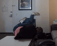 a person laying on their back in a living room with a picture on the wall that says ' a ' on it