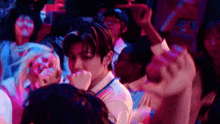 a man is standing in a crowd of people at a concert .