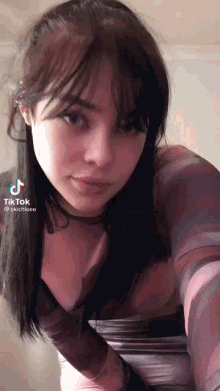 a girl taking a selfie with a tik tok watermark