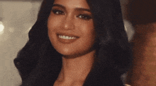 a close up of a woman 's face with her eyes closed and a smile on her face .
