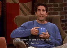 a man is sitting in a chair holding a blue cup and saying " ah humor based on my pain "