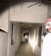 a man walking down a hallway with a cell phone