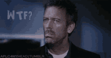 a man with a beard is making a funny face in front of a wall that says wtf ?