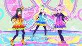 three anime girls are dancing on a stage in front of a colorful background