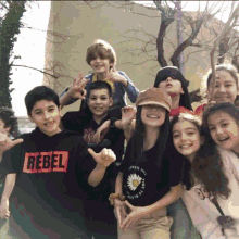 a group of kids posing for a picture with one wearing a rebel shirt