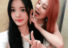 a woman with red hair is holding another woman 's hair