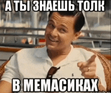 a man in a white shirt is pointing at the camera with a meme in russian behind him