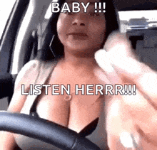 a woman is driving a car and talking on a cell phone while wearing a bra .