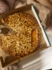 a pizza with a slice missing is in a cardboard box