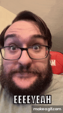 a man with glasses and a beard says " eeeeyeah "
