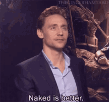 a man in a suit and blue shirt is talking about being naked .