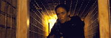 a woman is holding a gun and looking out of a doorway