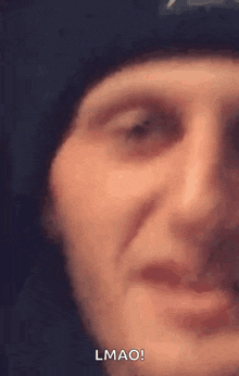 a close up of a man 's face with a hat on .