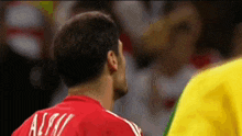 a man wearing a red shirt with the name alwi on the back