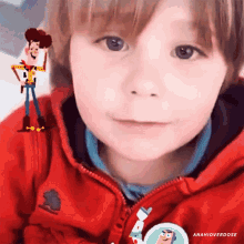 a young boy wearing a red jacket has a toy story woody sticker on his chest