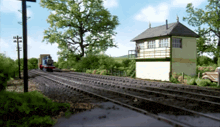 a train is going down the tracks in front of a building