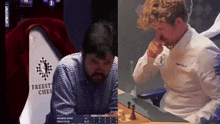 two men are playing chess in front of a freest chess sign