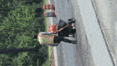 a construction worker is pushing a wheelbarrow down a road