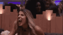 a woman is screaming with her mouth open while sitting in a theatre .