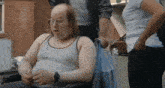 a man in a wheelchair is talking to a woman in a blue shirt