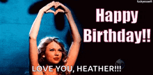 a woman is making a heart shape with her hands on a birthday card .
