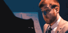 a man in a suit and tie is looking down